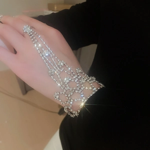 Sparkling silver ring bracelet with four parallel rhinestone chains and fringed tassel design