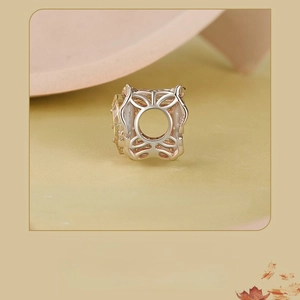 Macro shot of S925 silver charm with champagne stone and hollow floral pattern