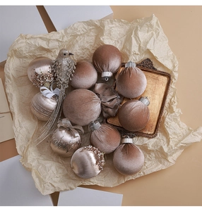Flat lay of champagne and velvet Christmas ornaments with a glittery bird pendant decoration