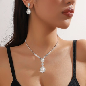 Elegant silver jewelry set with teardrop faux pearls and rhinestones on female model