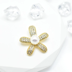 Golden sunflower pearl pendant with micro-pave crystals on a white geometric stand