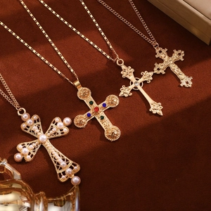 Detail of vintage gold cross necklaces with pearls and colorful gemstones on velvet