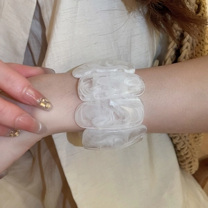 Detail of marble pattern acrylic bracelet with white resin irregular block beads