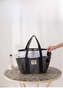 Mesh beach bag detail showing external pockets for sunglasses and toiletries storage
