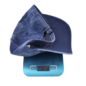 Detail shot showing a washed blue vintage baseball cap on a scale weighing 72 grams