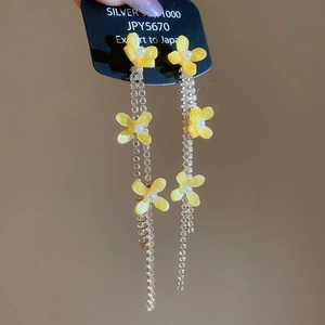 Detail of S925 silver earrings with yellow flowers, pearls and long zircon tassels