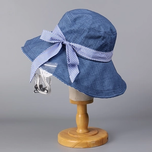 Detail of blue denim sun hat featuring a striped bow and adjustable windproof rope