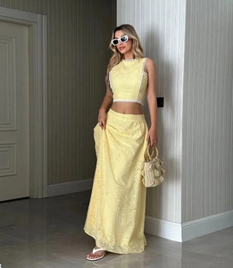 Vue détaillée de l'ensemble haut en dentelle jaune et jupe longue avec sac tissé