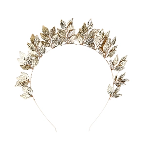 Macro detail of golden metal leaf headband featuring intricate hollow leaf textures