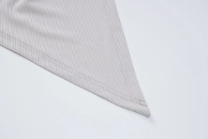 Vue macro d'une robe en maille côtelée grise avec détails de coutures à double aiguille