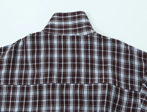 Close-up of classic brown and blue plaid shirt collar with detailed shoulder stitching