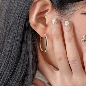 Detailed view of gold plated 925 silver hoop earrings featuring sparkling cubic zirconia