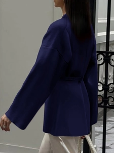 Side view of elegant navy blue long-sleeved jacket with waist-tie and loose fit
