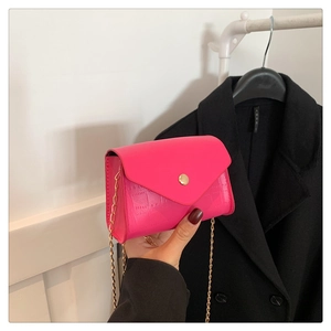 Detail of fuchsia stone-patterned crossbody bag with gold chain strap and snap closure