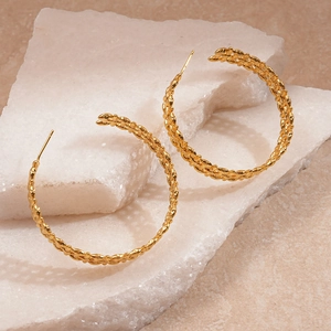 Detailed macro view of 18K gold plated C-shape hoop earrings with woven wheat pattern
