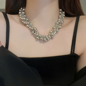 Detail view of multi-layered silver bead cluster choker necklace on model neckline