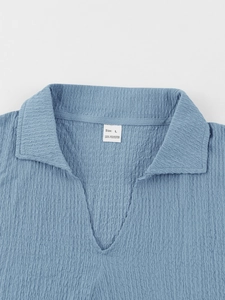 Close-up of blue seersucker textured fabric collar showing the size L label clearly
