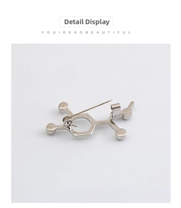 Macro detail of silver chemical molecule badge with secure clasp and polished finish