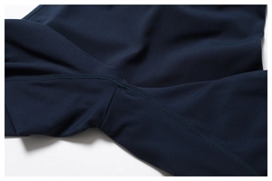 Détail de couture plate sur combinaison de yoga bleu marine montrant des finitions pro