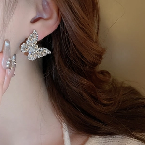Close-up of sparkling butterfly stud earrings with rhinestones on a silver base