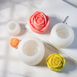 Vue détaillée des moules en silicone rose et bougies florales finies en plusieurs tailles
