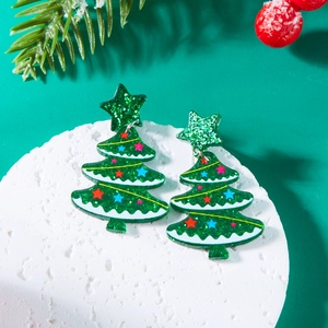 Detailed view of sparkly green Christmas tree acrylic earrings with festive pine decor