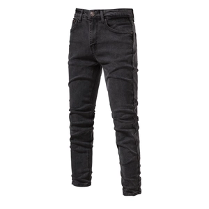Close-up of black denim jeans showing washed texture and premium stitching details
