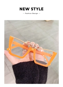 Detail of bright orange cat eye glasses frame with elegant gold metal top bar accents