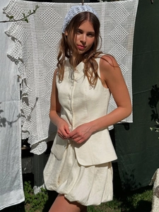 Détail de l'ensemble gilet et jupe bouffante en lin blanc crème avec tissu texturé