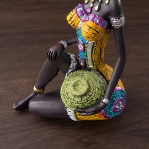 Close-up of African woman resin figurine with colorful clothing and glitter texture