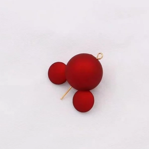 Macro detail of red matte beads in a mouse-shaped design for DIY jewelry making
