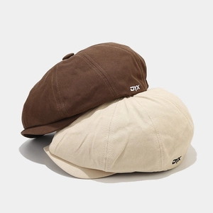 Detailed texture of cotton newsboy caps in brown and beige colors with DYX embroidery