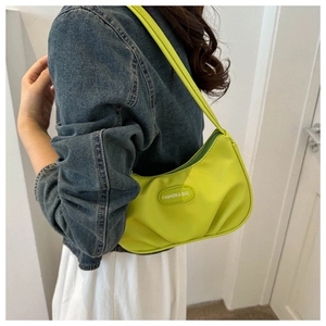 Vue détaillée du sac baguette vert fluo porté par le mannequin montrant le profil