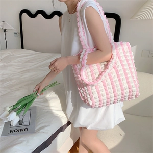 Detail of pink and white checkered popcorn fabric tote with ruffle strap texture
