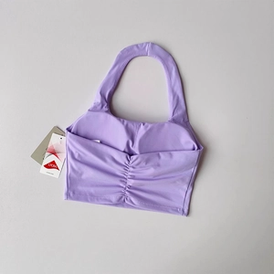 Detailed flat lay of lavender ruched halter neck sports bra featuring Lycra fabric tag