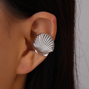 Detailed view of silver shell-shaped ear cuff featuring textured metallic radial patterns