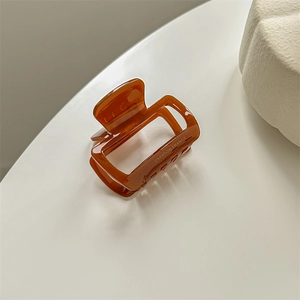 Macro shot of amber acetate hair claw with Creation France engraving detail