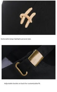 Detail of golden H embroidery and vintage copper metal buckle on black cotton baseball cap