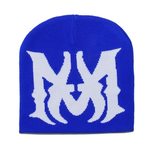 Close-up of knit texture and white jacquard M logo on a blue winter beanie