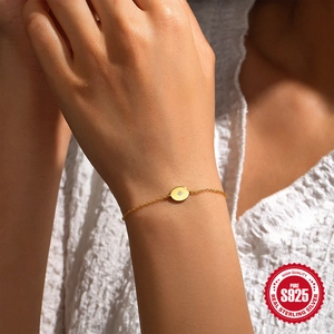 Minimalist S925 sterling silver gold bracelet with diamond-set round disc on model's wrist