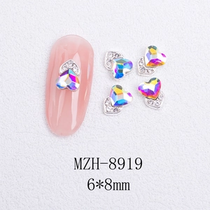 Macro shot of 6x8mm heart-shaped AB rhinestone nail charms with silver metal edging