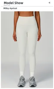 Detail of high waisted ribbed yoga pants in cream color with wide waistband and textured fabric