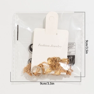 Detail of gold fringe necklace with rhinestones on card packaging with 9cm size label
