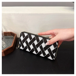 Macro detail of the long clutch wallet featuring black and white geometric woven textures