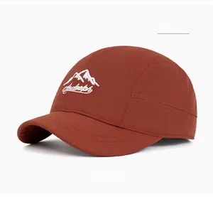 Detail of short brim baseball cap in caramel red with embroidered mountain logo