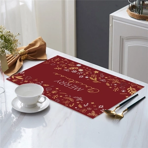 Macro detail of wine red Christmas placemat with golden reindeer and snowflake motifs