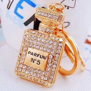 Macro shot of gold perfume bottle keychain with crystal rhinestones and N°5 engraving