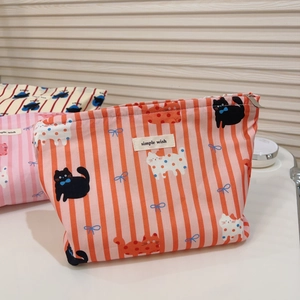 Gros plan détaillé d'une trousse de maquillage en coton avec imprimé chat et fermeture éclair