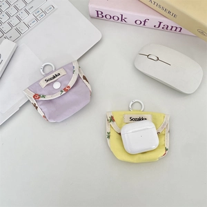 Macro view of contrast color fabric earphone case with white snap button and carabiner clip