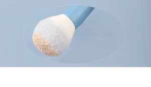 Macro shot of blue makeup brush bristles capturing powder for easy application